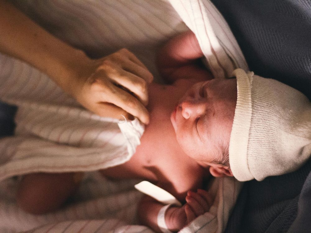 mãe secando bebê de 1 mês após o banho