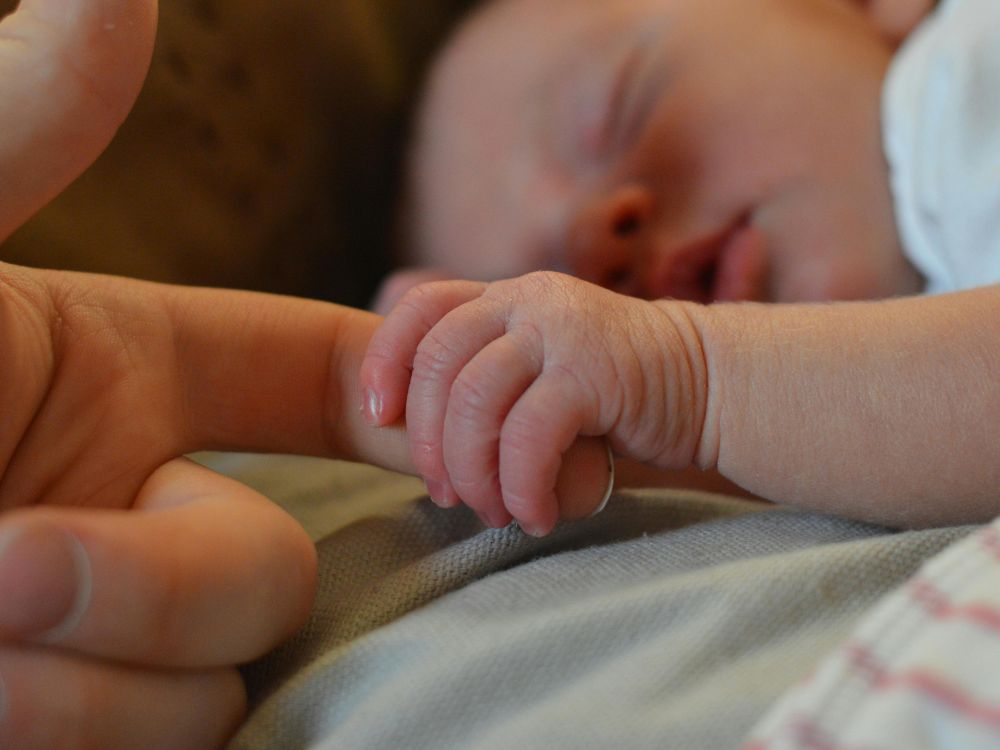 bebê de 1 mês apresentando o reflexo de preensão palmar