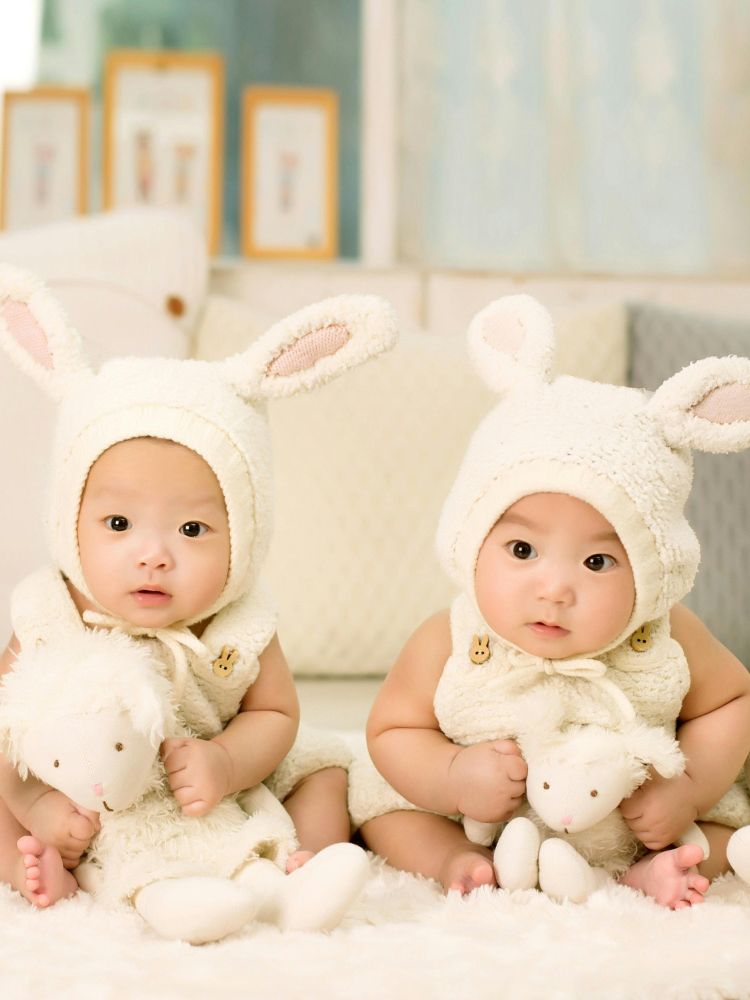 dois bebês de 6 meses vestidos de coelhos