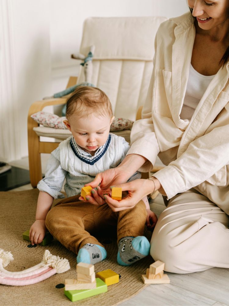 bebê de 6 meses brincando de montar blocos com a mãe