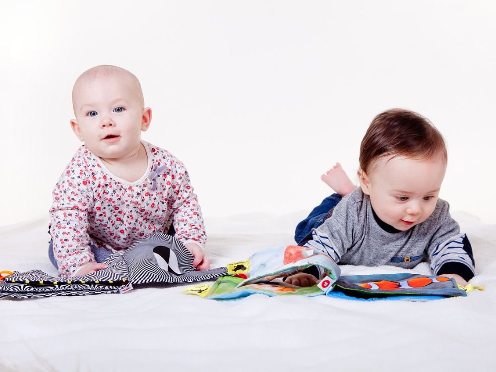 bebê de 6 meses manipulando livros com cores contrastantes 