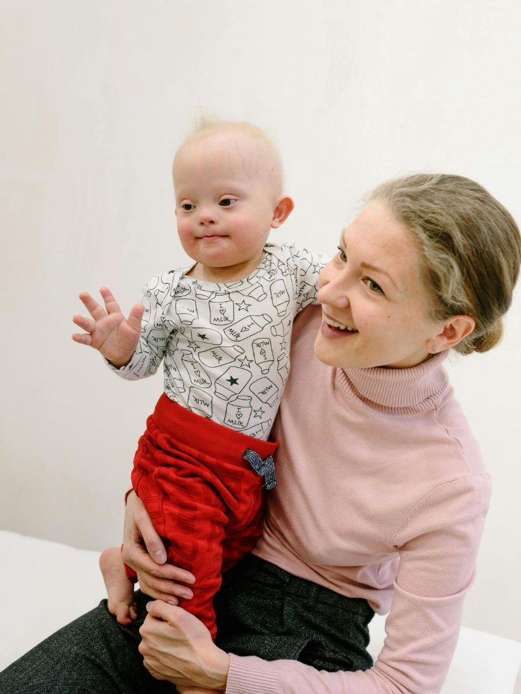 mãe segurando seu filho com síndrome de Down, representando a maternidade atípica