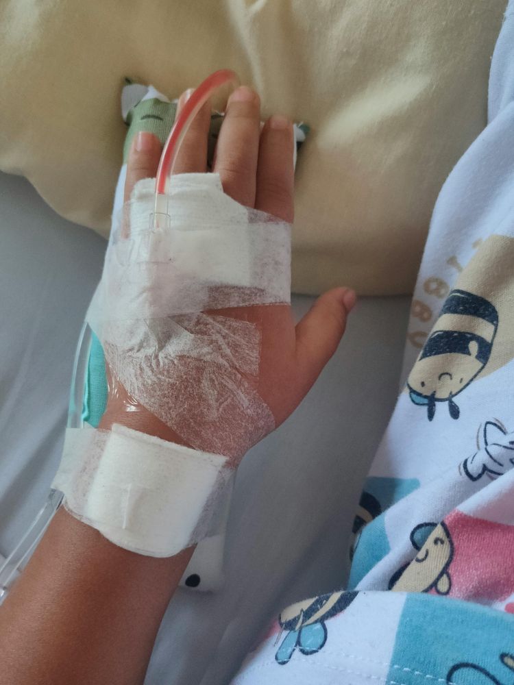 criança com acesso venoso na mão, representando a maternidade atípica