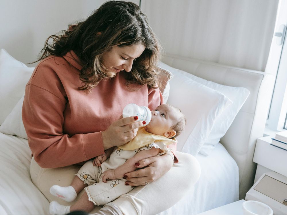 bebê realizando contato visual com a mãe durante a amamentação, sem sinais de autismo em bebês