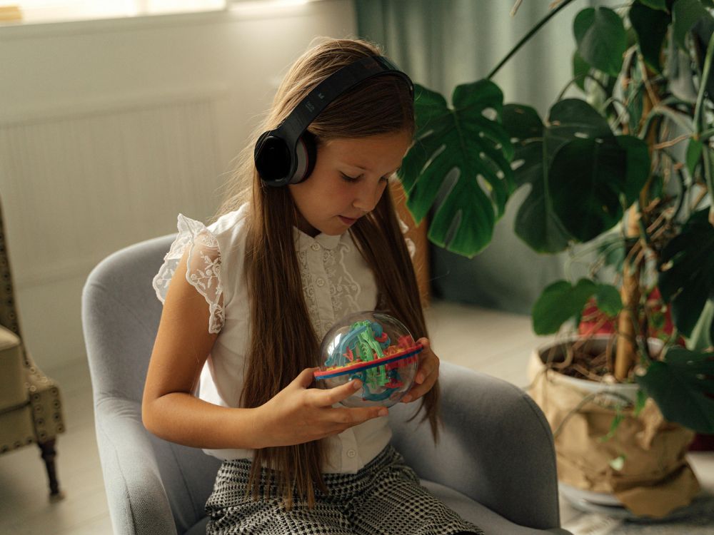 menina com sensibilidade aumentada utilizando fones de ouvido, com sinais de autismo