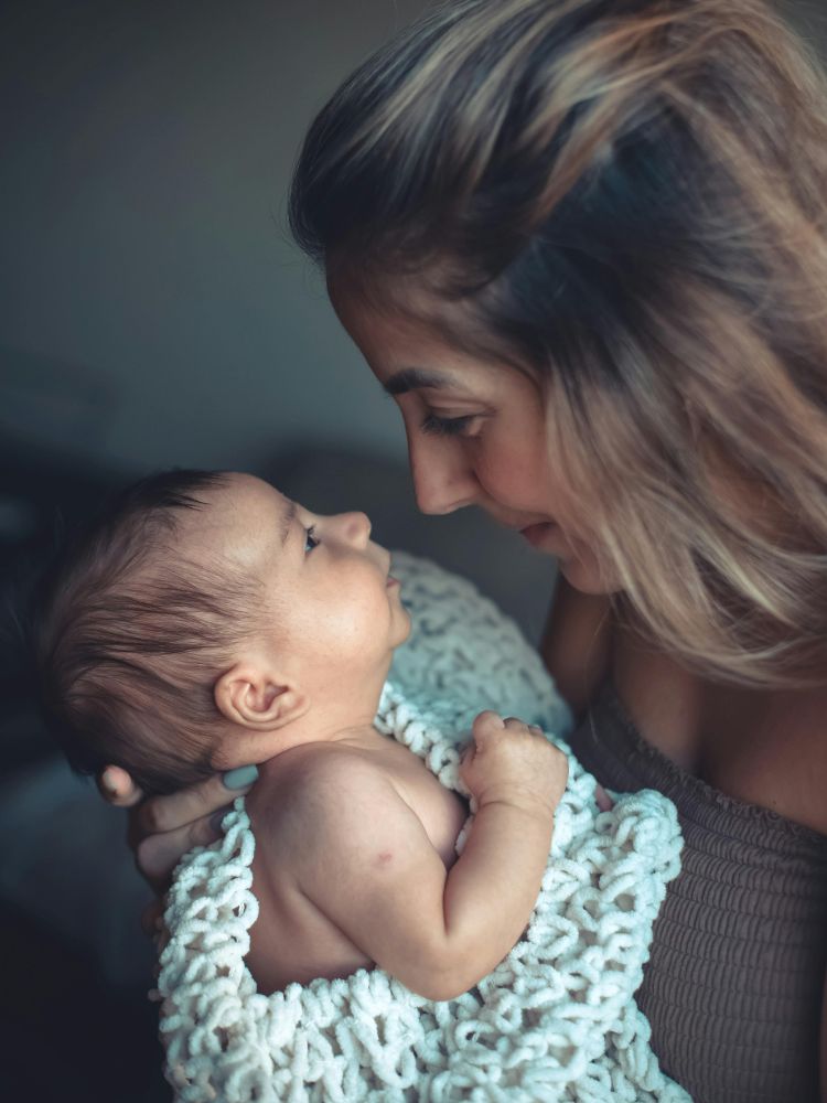 mãe realizando contato visual com seu bebê de 3 meses, estimulando a interação social