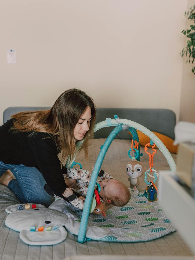 bebê de 3 meses deitado vendo móbile colorido